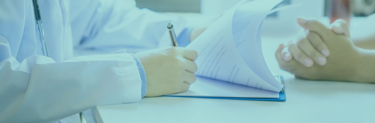 Young handsome physician in a medical robe with stethoscope